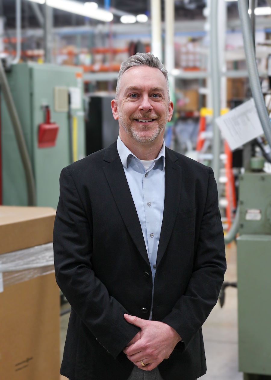 DaveK John Danes in a blue button up long sleeve, smiling with arms crossed